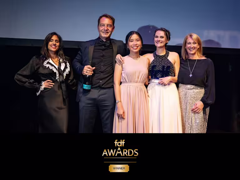 Gold and black "fdf Awards" logo with the word "WINNER" in a gold ticket-shaped label below the title.