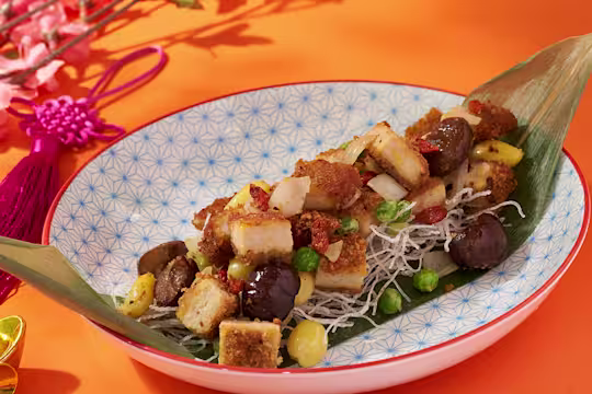 Quorn hot and spicy burger pieces arranged on a banana leaf with nuts, seeds and berries.