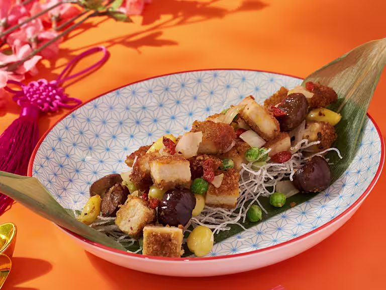 Quorn hot and spicy burger pieces arranged on a banana leaf with nuts, seeds and berries.