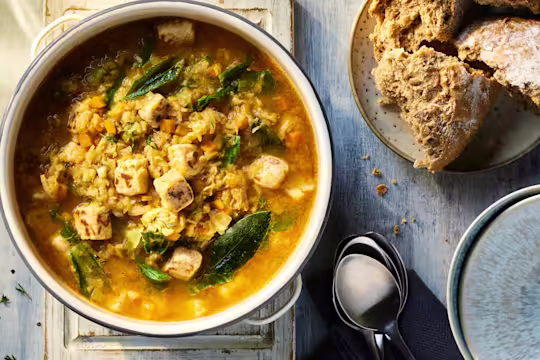 Vegetarian Lentil Soup with Quorn Pieces visible on the top and served alongside crusty bread.