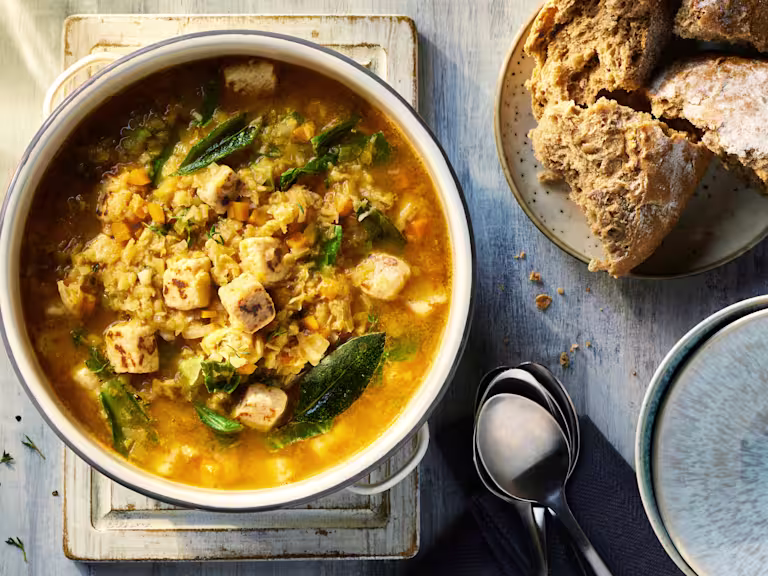 Vegetarian Lentil Soup with Quorn Pieces visible on the top and served alongside crusty bread.