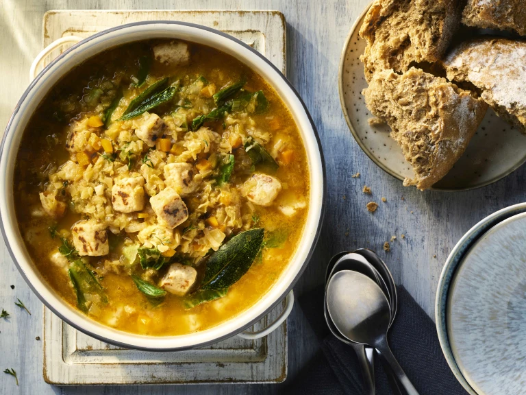 Vegetarian Lentil Soup with Quorn Pieces visible on the top and served alongside crusty bread. 