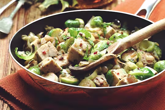 Quorn Roast, Brussels sprouts, leeks, and onion in a pan.