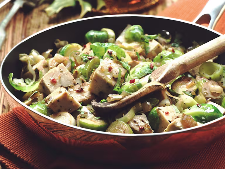 Quorn Roast, Brussels sprouts, leeks, and onion in a pan.