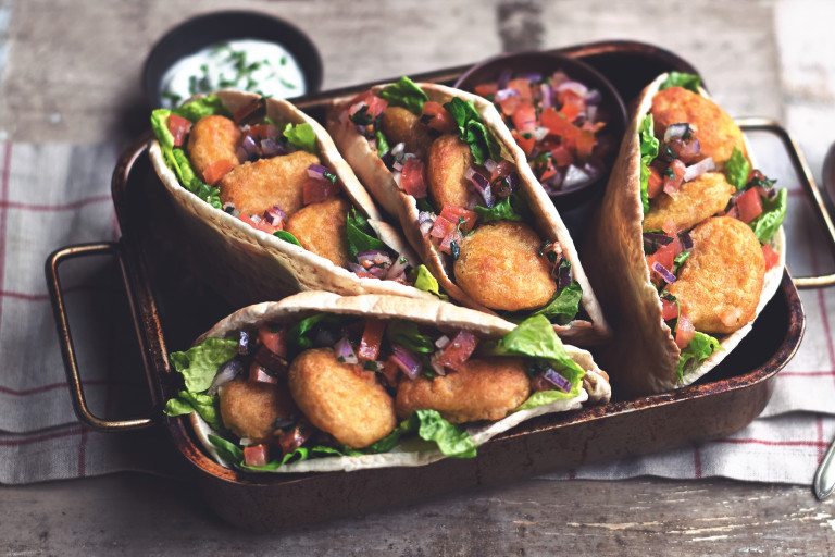 A tray of kebab style Quorn Meat Free Crispy Nuggets served in pitta bread with a yoghurt dip.