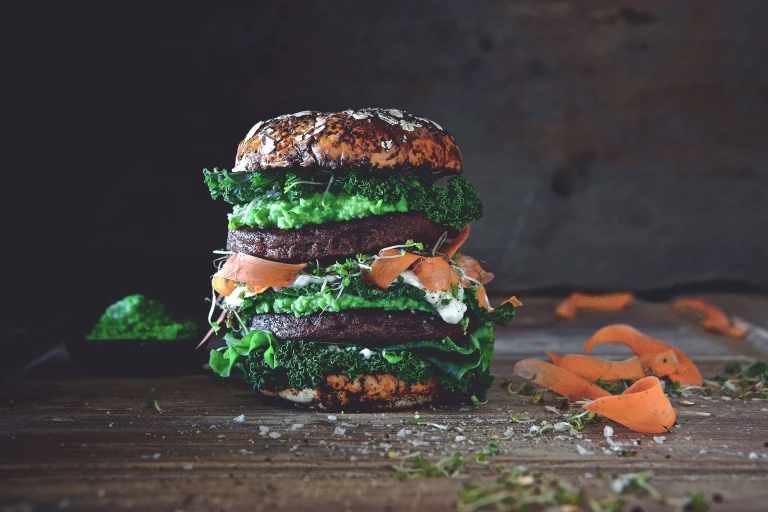 Quorn Ultimate Vegetarian Green Burger with shavings of carrots by the side.