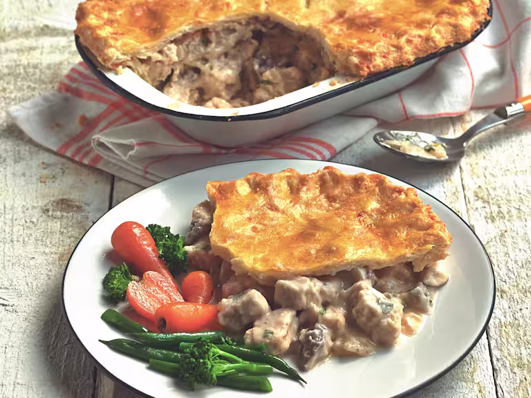 Vegetarian recipe of Quorn Gluten Free Pieces and mushroom pie served with carrots, broccoli and green beans in a white dish