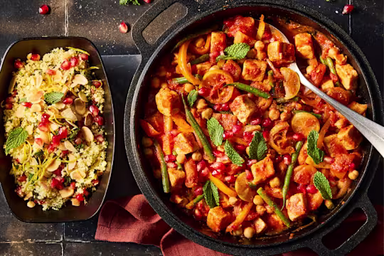 Moroccan Stew with Quorn Pieces, chickpeas and fresh vegetables in a serving dish with a side of cous cous.