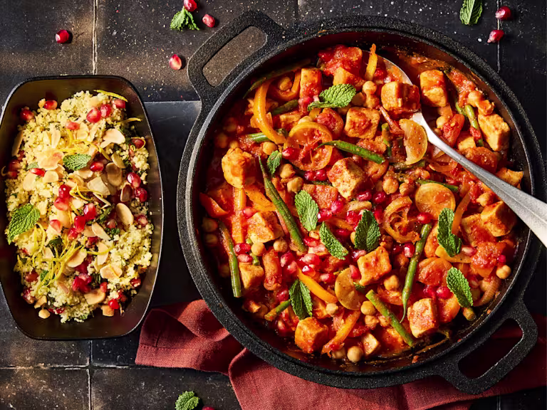 Moroccan Stew with Quorn Pieces, chickpeas and fresh vegetables in a serving dish with a side of cous cous.