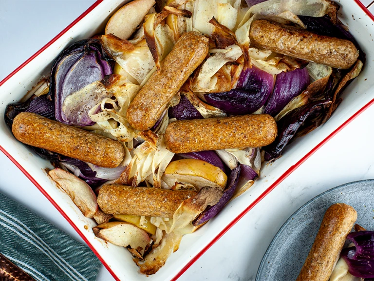 Vegan fruit apple and  sausage tray bake with Quorn's Brilliant Bangers served in a baking tray.