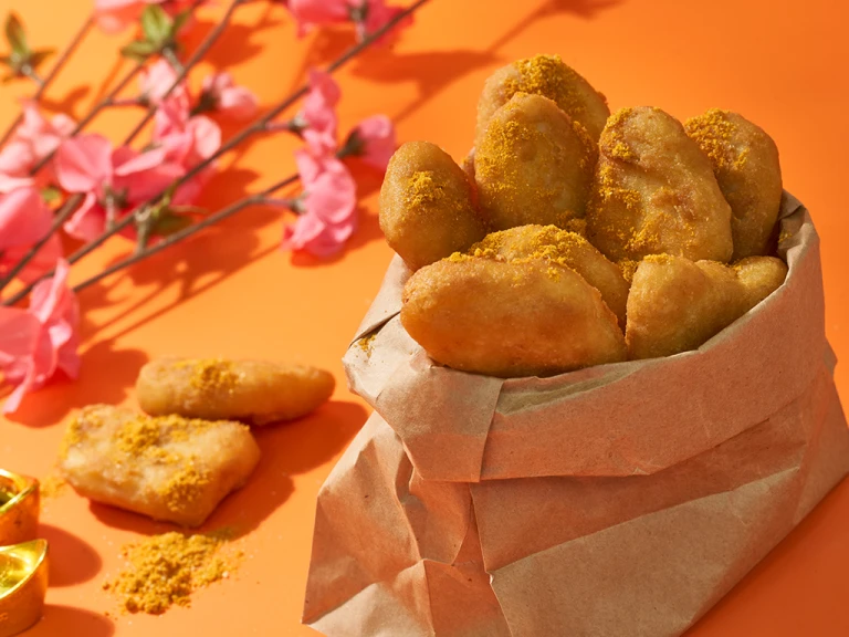 Quorn nuggets in pot lined with brown paper, next to some pink flowers