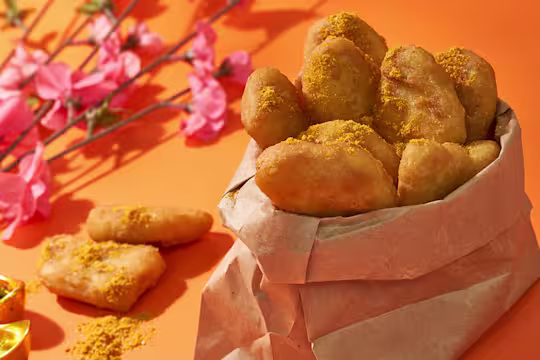 Quorn nuggets in pot lined with brown paper, next to some pink flowers