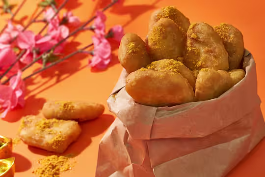 Quorn nuggets in pot lined with brown paper, next to some pink flowers