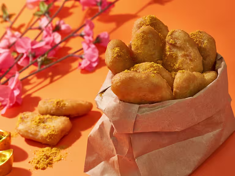 Quorn nuggets in pot lined with brown paper, next to some pink flowers