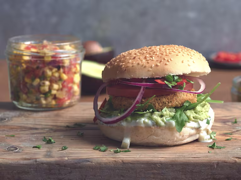 Vegan burger made with Quorn Vegan Hot and Spicy Burgers with salad, smashed avocado, tomato and onion in a bun
