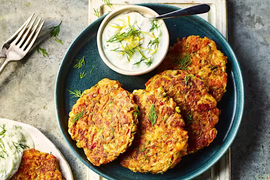 Four Quorn Smoky Ham Free Vegan Fritters served alongside a dip on a blue dish.