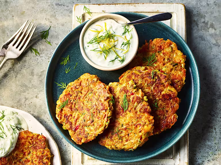 Four Quorn Smoky Ham Free Vegan Fritters served alongside a dip on a blue dish.