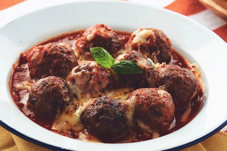 A dish filled with pasta topped with meatballs made with Quorn Mince and covered with melted cheese.