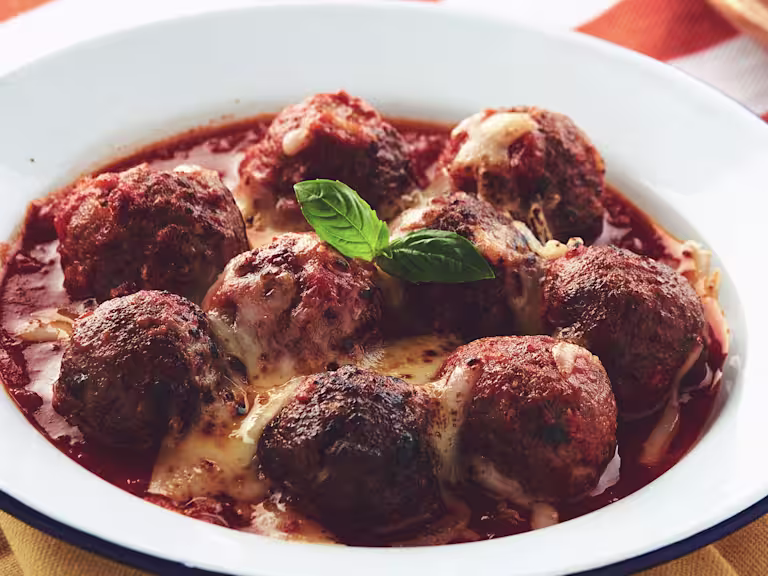 A dish filled with pasta topped with meatballs made with Quorn Mince and covered with melted cheese.