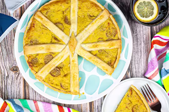 Vegetarian quiche served on a blue plate with a slide served on the side.