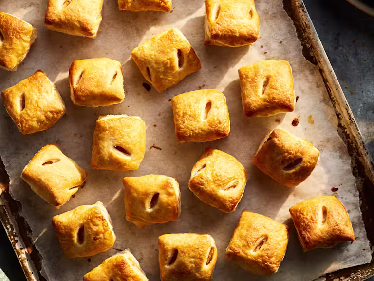 Quorn Vegetarian Chicken & Leek Family Pie served on a blue plate with peas, carrots and mashed potato. A silver fork is set to the right of the plate and a serving bowl of peas and carrots is top left.