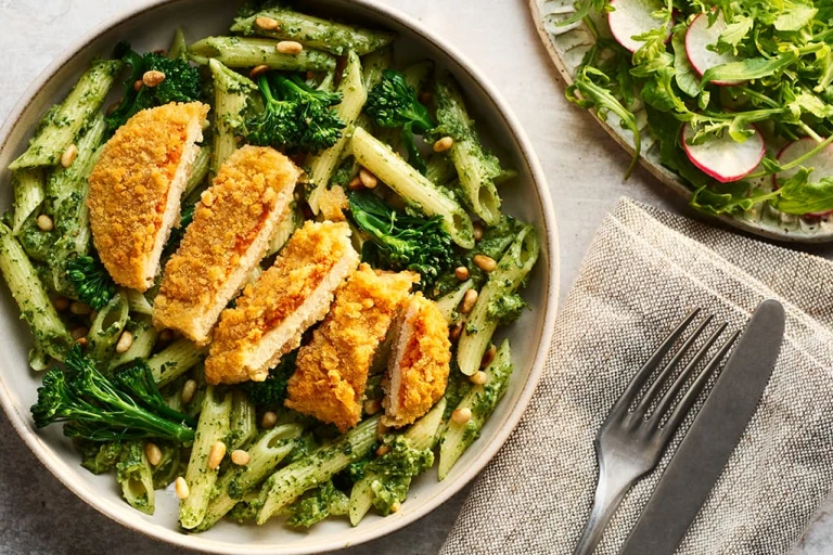 Quorn Escalopes with Broccoli Pesto Pasta on a plate with a salad on the side