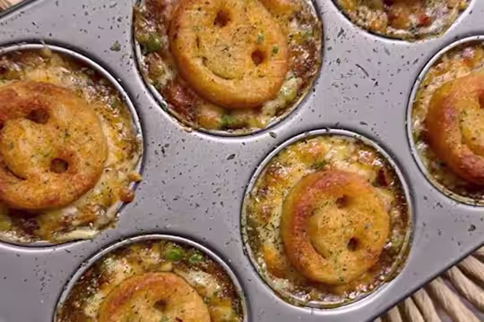 Several Smiley Face Mini Vegetarian Shepherd’s pies served in a baking tray.