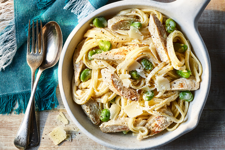Creamy Crème Fraiche Pasta with Quorn Fillets served in a white dish with a fork and spoon on the side.