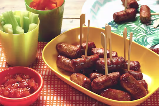 Quorn Vegetarian Cocktail Sausages on a stick made with celery, carrots and salsa, served on a plate