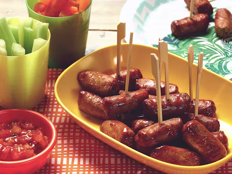 Quorn Vegetarian Cocktail Sausages on a stick made with celery, carrots and salsa, served on a plate