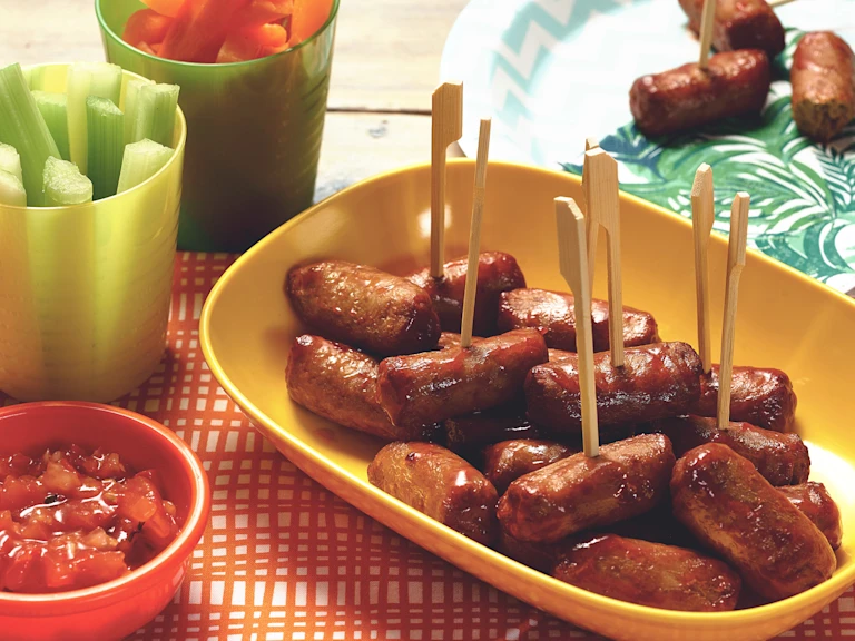 Quorn Vegetarian Cocktail Sausages on a stick made with celery, carrots and salsa, served on a plate