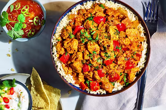 Quorn Vegetarian Tikka Masala served on a bed of rice with sauce on the side.