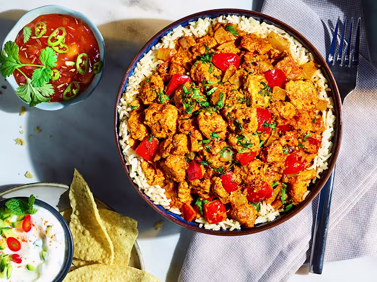 Quorn Vegetarian Tikka Masala served on a bed of rice with sauce on the side.