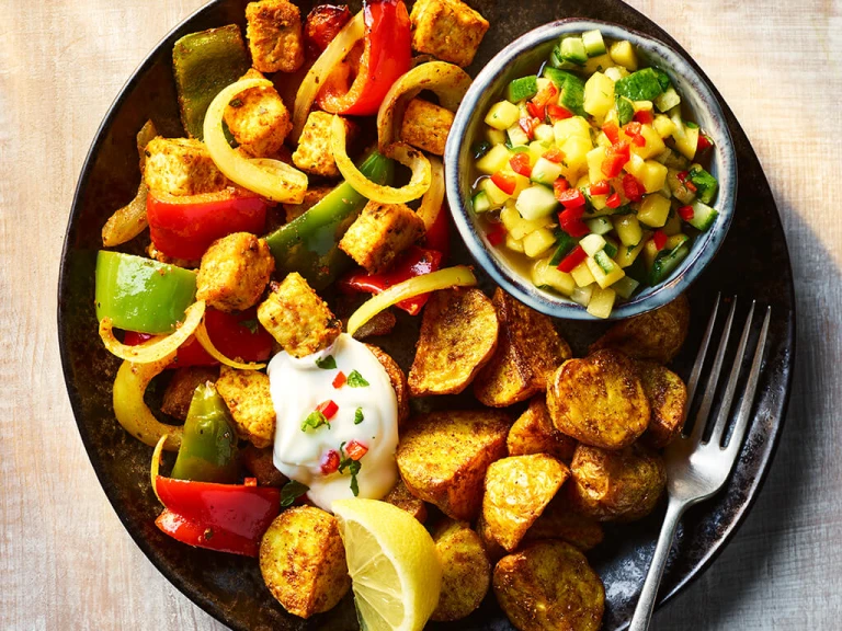 Quorn Pieces Tikka with Bombay potatoes and mango and cucumber chutney on a plate