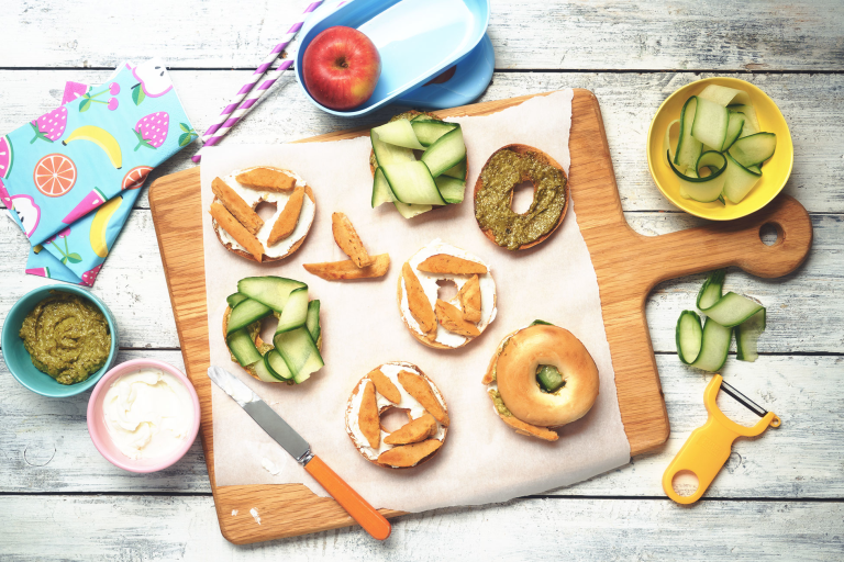 Easy lunch recipe of bagels on a wooden board topped with cucumber, pesto and Quorn Roasted Fillets