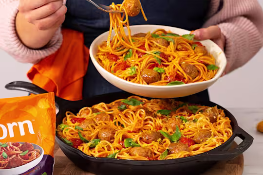 Meatball bake served in a frying pan with a serving in a white bowl. Quorn Swedish style balls on the side.