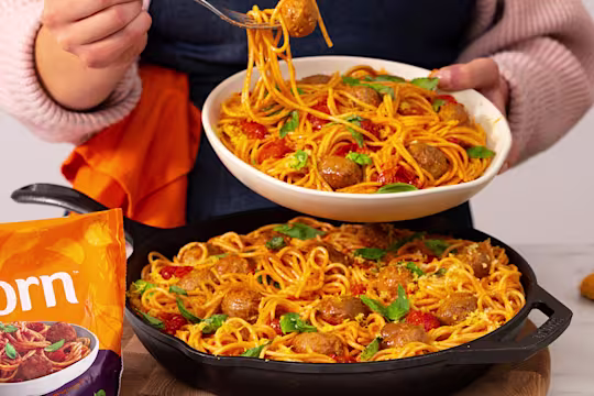 Meatball bake served in a frying pan with a serving in a white bowl. Quorn Swedish style balls on the side.