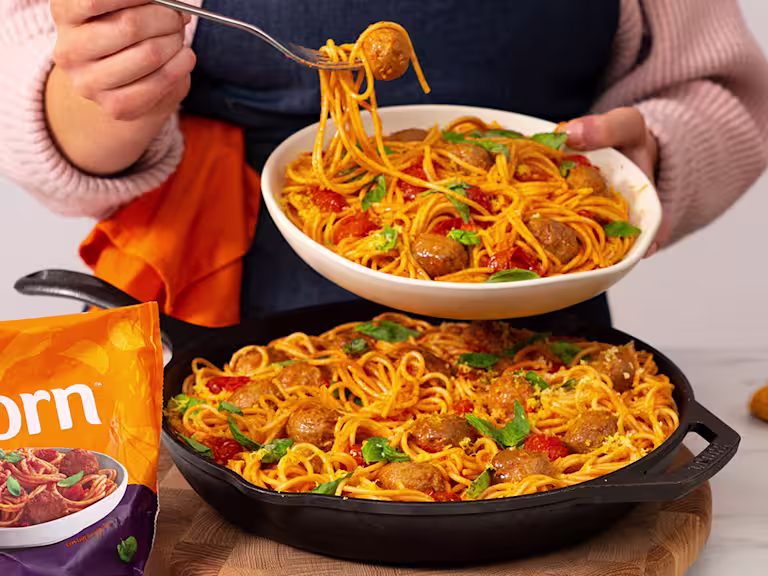 Meatball bake served in a frying pan with a serving in a white bowl. Quorn Swedish style balls on the side.