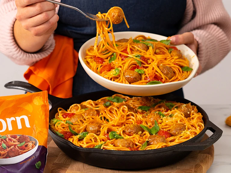 Meatball bake served in a frying pan with a serving in a white bowl. Quorn Swedish style balls on the side.