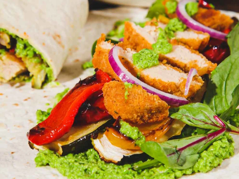 Quorn Crunchy Fillet Burger Vegan Wrap sliced in half to show the filling with an open wrap in the shot.