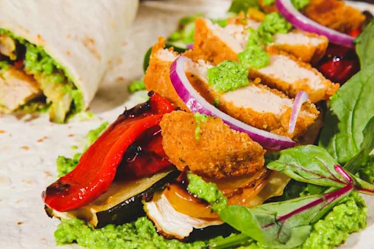 Quorn Crunchy Fillet Burger Vegan Wrap sliced in half to show the filling with an open wrap in the shot.