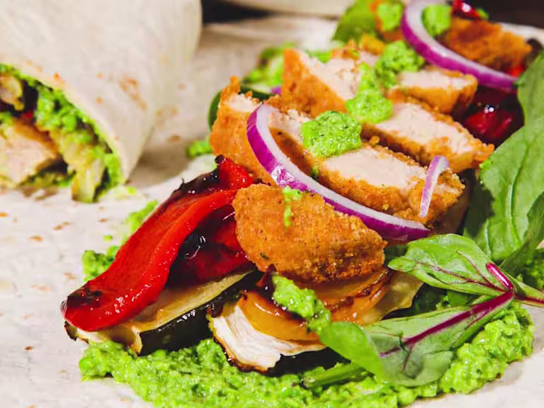 Quorn Crunchy Fillet Burger Vegan Wrap sliced in half to show the filling with an open wrap in the shot.