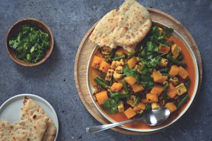 Gele linzencurry met pompoen, stukjes dés en platbrood