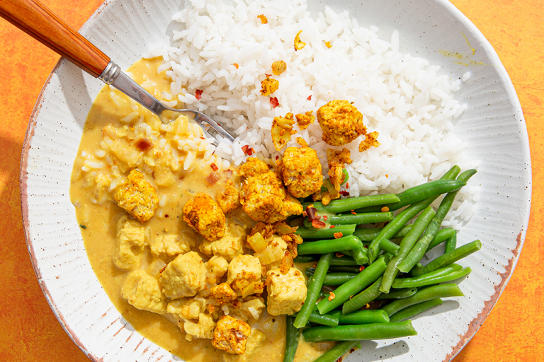 Panang creamy Quorn Pieces curry with white rice and green beans in a bowl