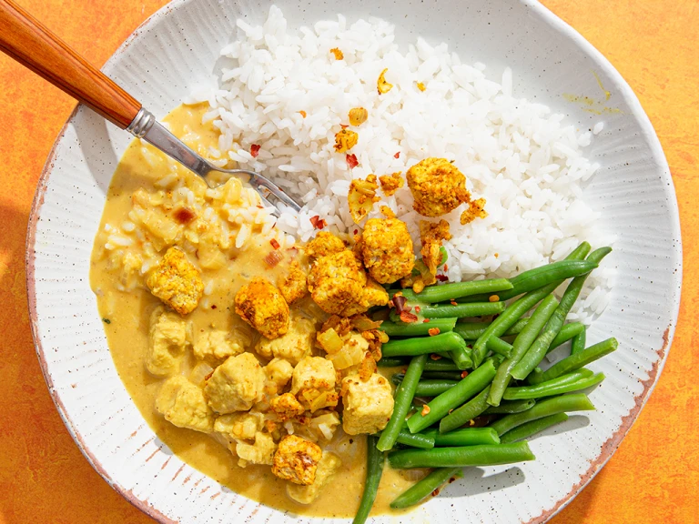 Panang creamy Quorn Pieces curry with white rice and green beans in a bowl