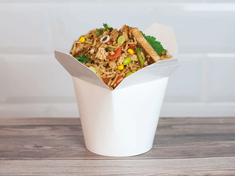 A white Chinese takeout container filled with air fryer fried rice made with Quorn Vegan Fillets.