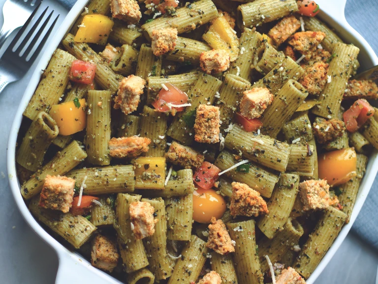 A vegan pesto pasta salad topped with diced Quorn Spicy Vegan Pieces.