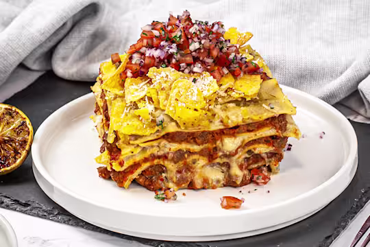 A portion of Mexican lasagne served on a white dish.
