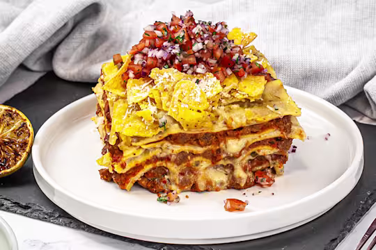 A portion of Mexican lasagne served on a white dish.