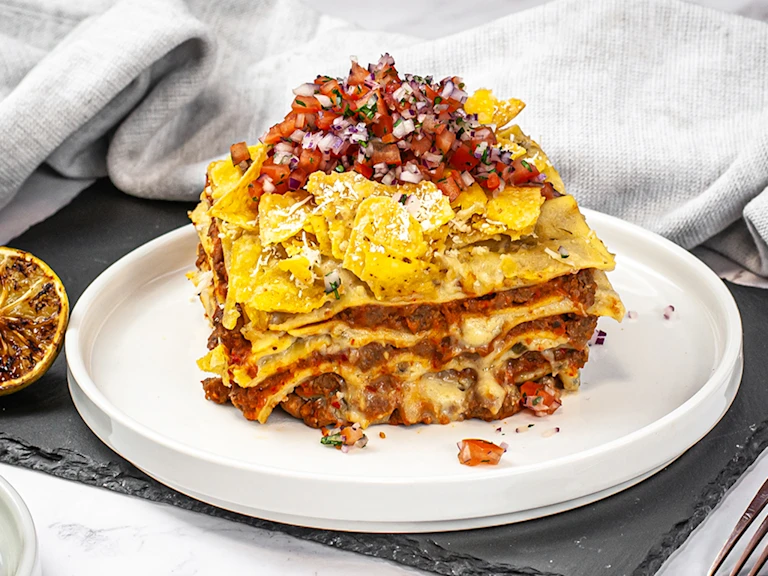 A portion of Mexican lasagne served on a white dish.